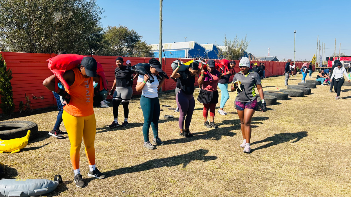 Participant lifting a sandbag during a wellness bootcamp