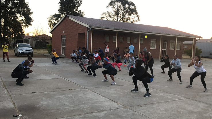 Bootcamp participants performing squats outdoors